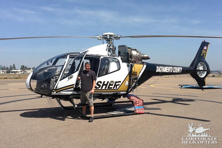Man stands next to completed EC120 helicopter after 12 year inspection