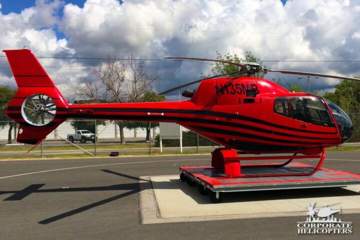 Cherry red and black 2007 Eurocopter EC-120B helicopter on a platform