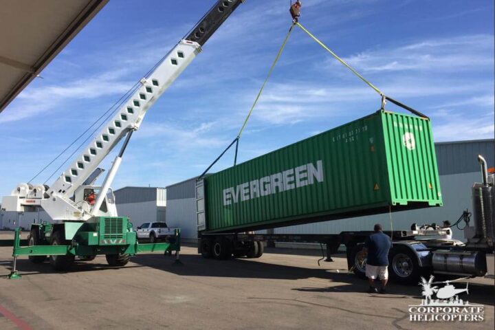 Evergreen shipping cargo container being lifted onto a semi truck by a crane