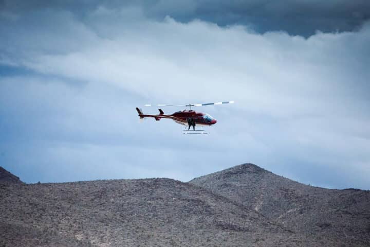 Helicopter flying over desert hills