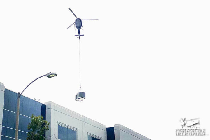 Helicopter lifting HVAC over a building