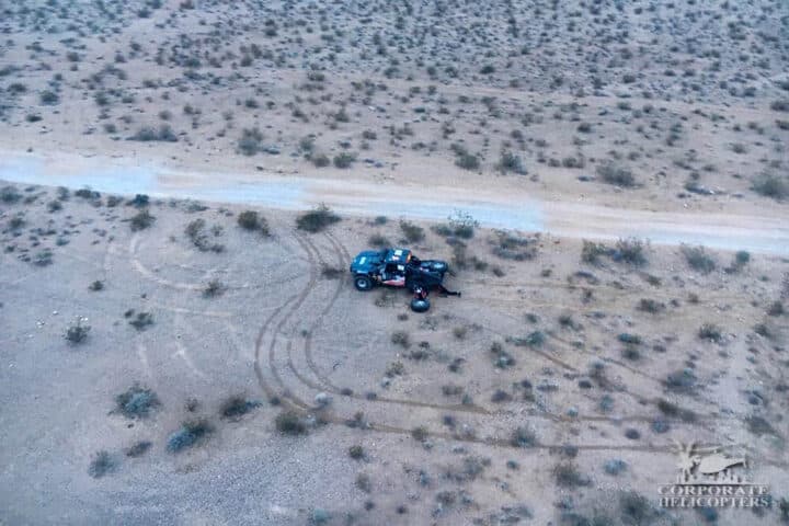 Aerial view of a broken down off road race vehicle in the desert