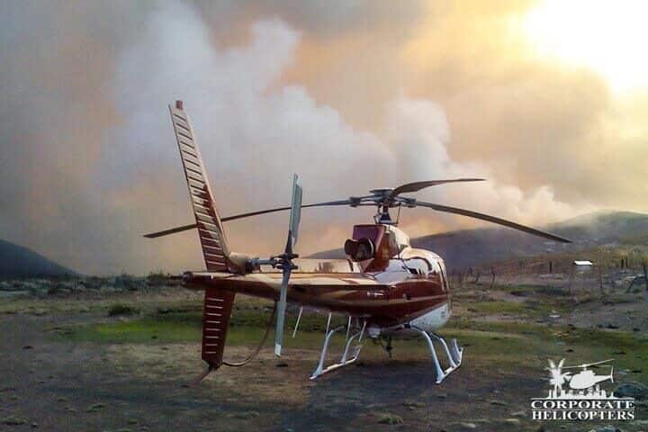 Helicopter landed in front of a large fire