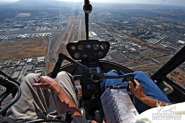 Point of view of two people flying a helicopter over an airport