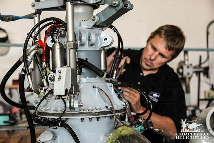 Man performing maintenance on helicopter rotor