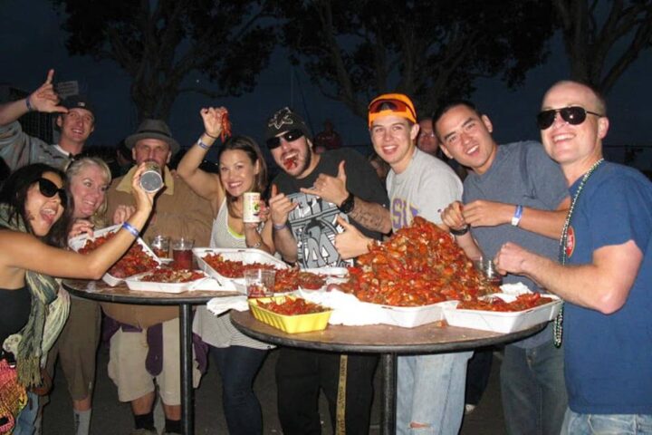 A group of people eat from a pile of crawfish at Gator By The Bay