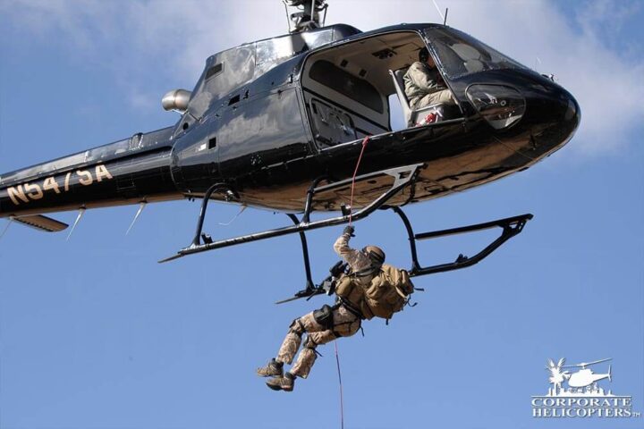 Man in Military-esque clothing repelling from a helicopter