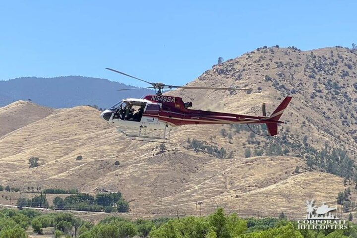 Helicopter flying against mountain backdrop in Kern County