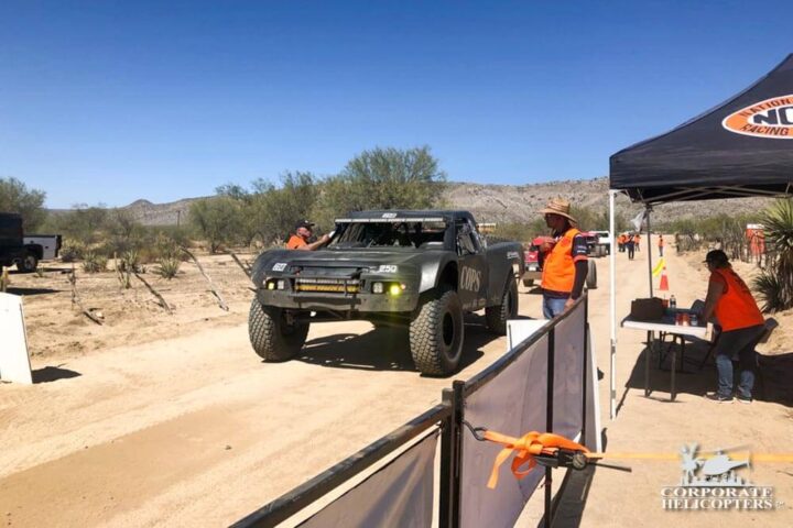 Off road race vehicle with race workers at a race tent