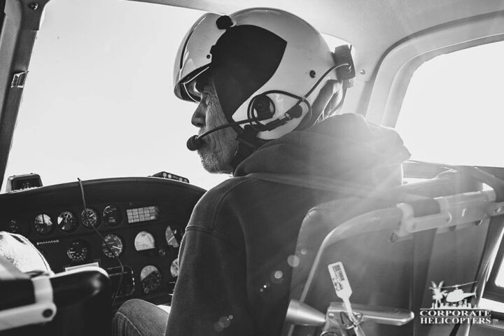 Black and white photo of a pilot flying a helicopter