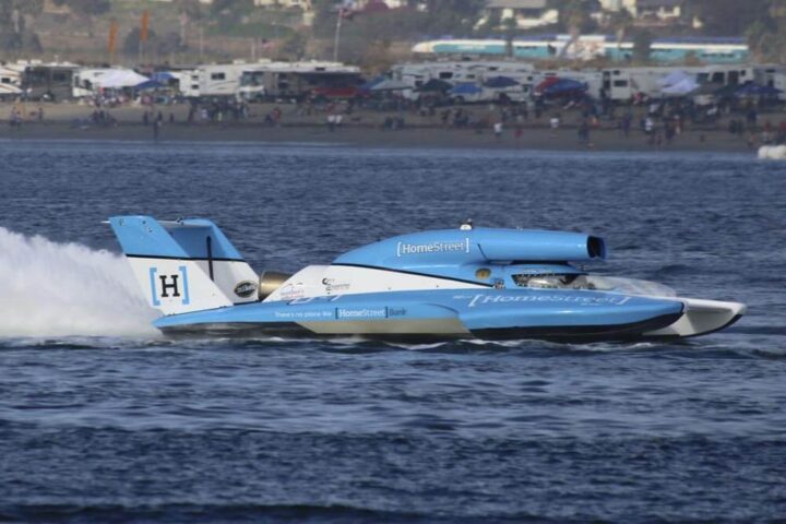 A blue thunderboat races across the water at San Diego Bayfair
