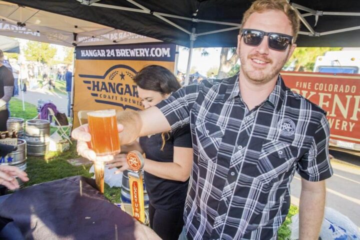 Man raises glass to camera at the San Diego Brew Festival
