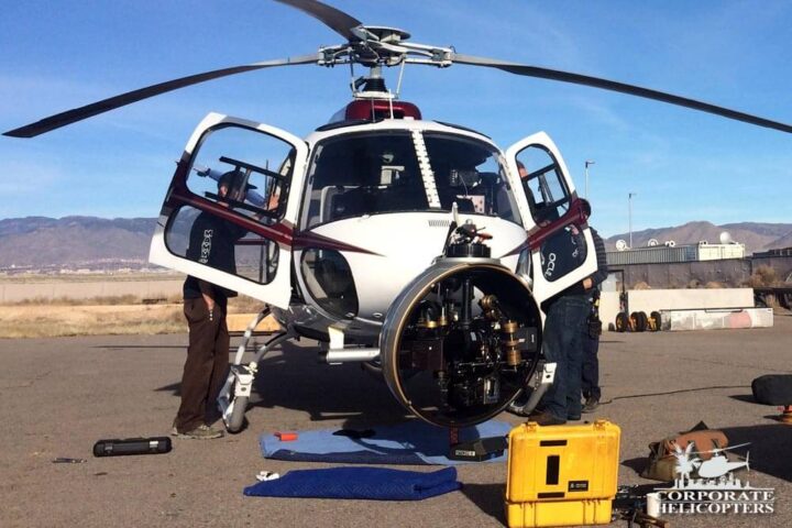 Men working on helicopter and nose-mounted helicopter camera system